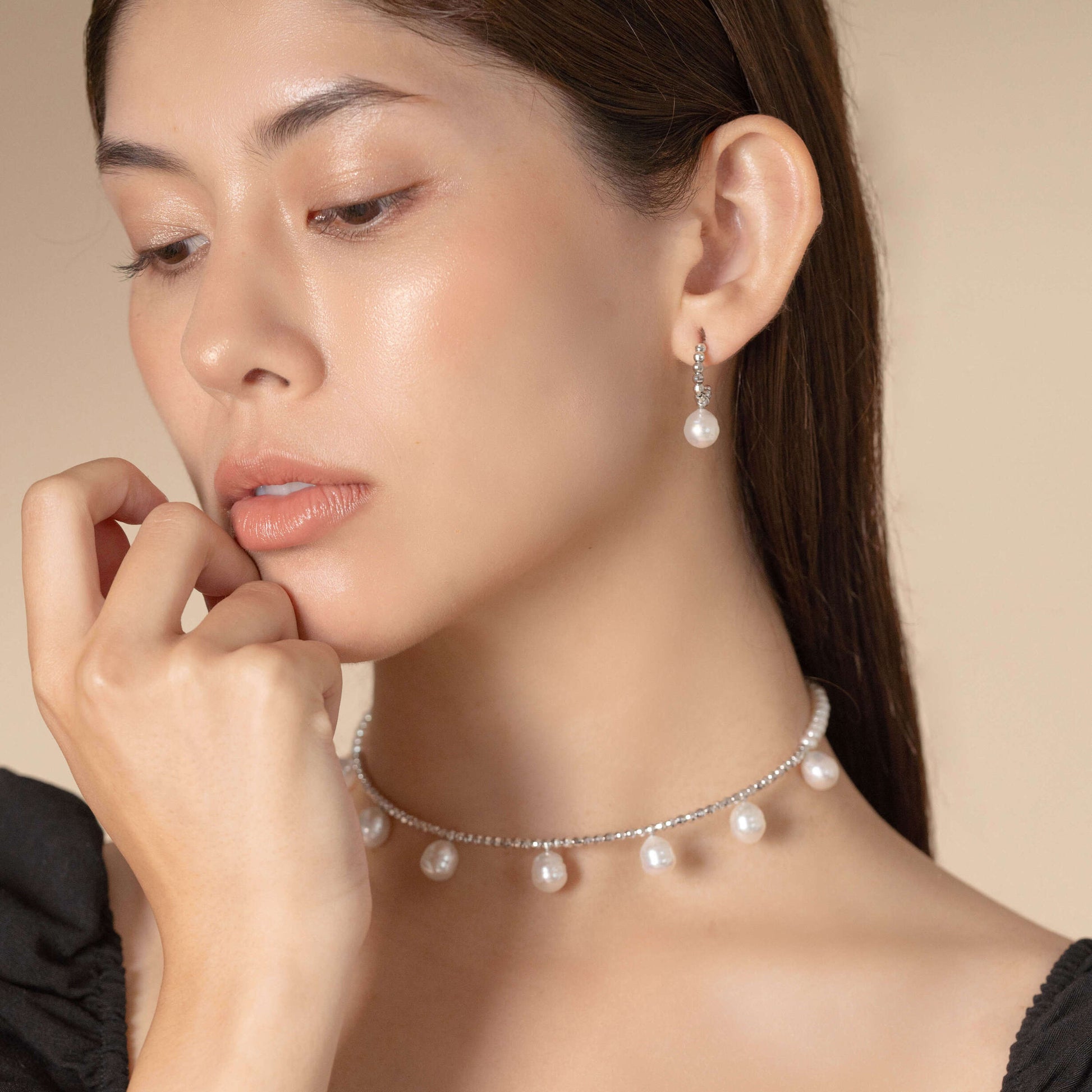 Enhance your elegance with a stunning woman adorned in a Pearl Dot x White Gold Pierce and necklace.
