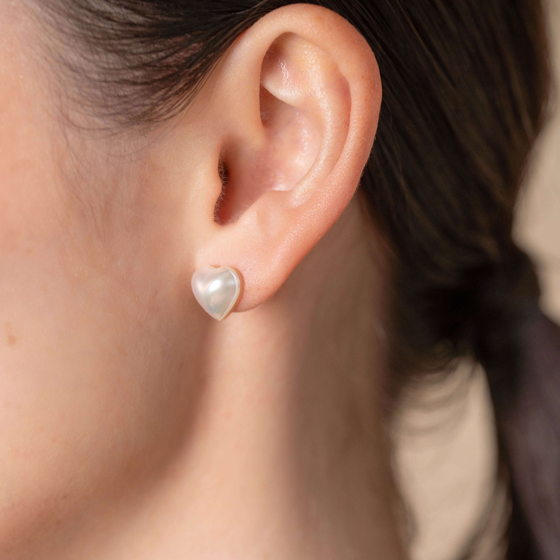 Elevate your look with Heart Pearl Stud Piercing earrings on a stylish woman.
