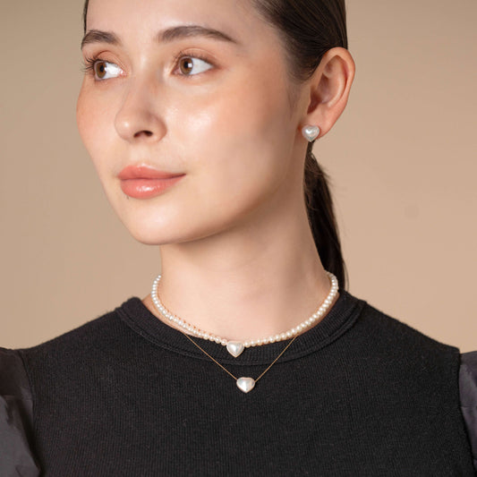 Enhance your style with elegance - a woman in a black top and pearl necklace exudes timeless beauty.