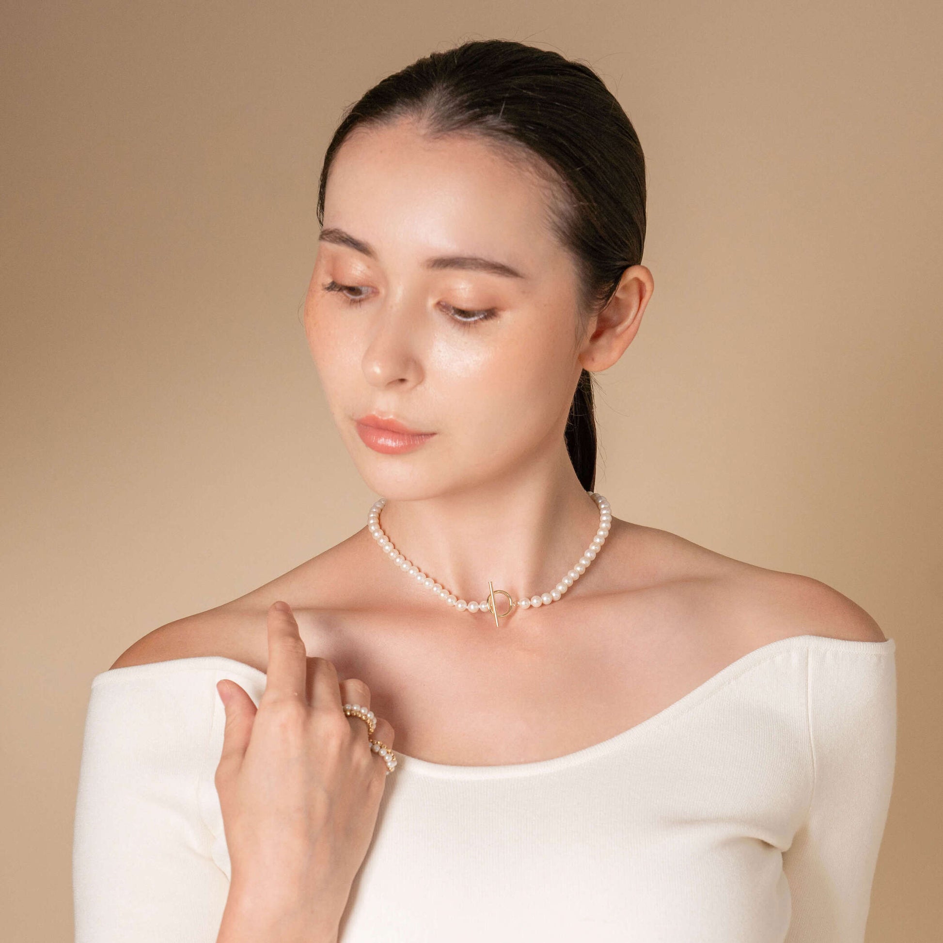 Enhance your style with a classic touch - woman in white top and pearl necklace. Mantel Pearl Necklace Short.