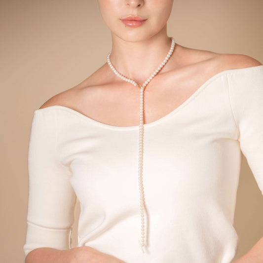 Enhance your elegance with a stunning woman in a white top and a Mantel Pearl Necklace Long.