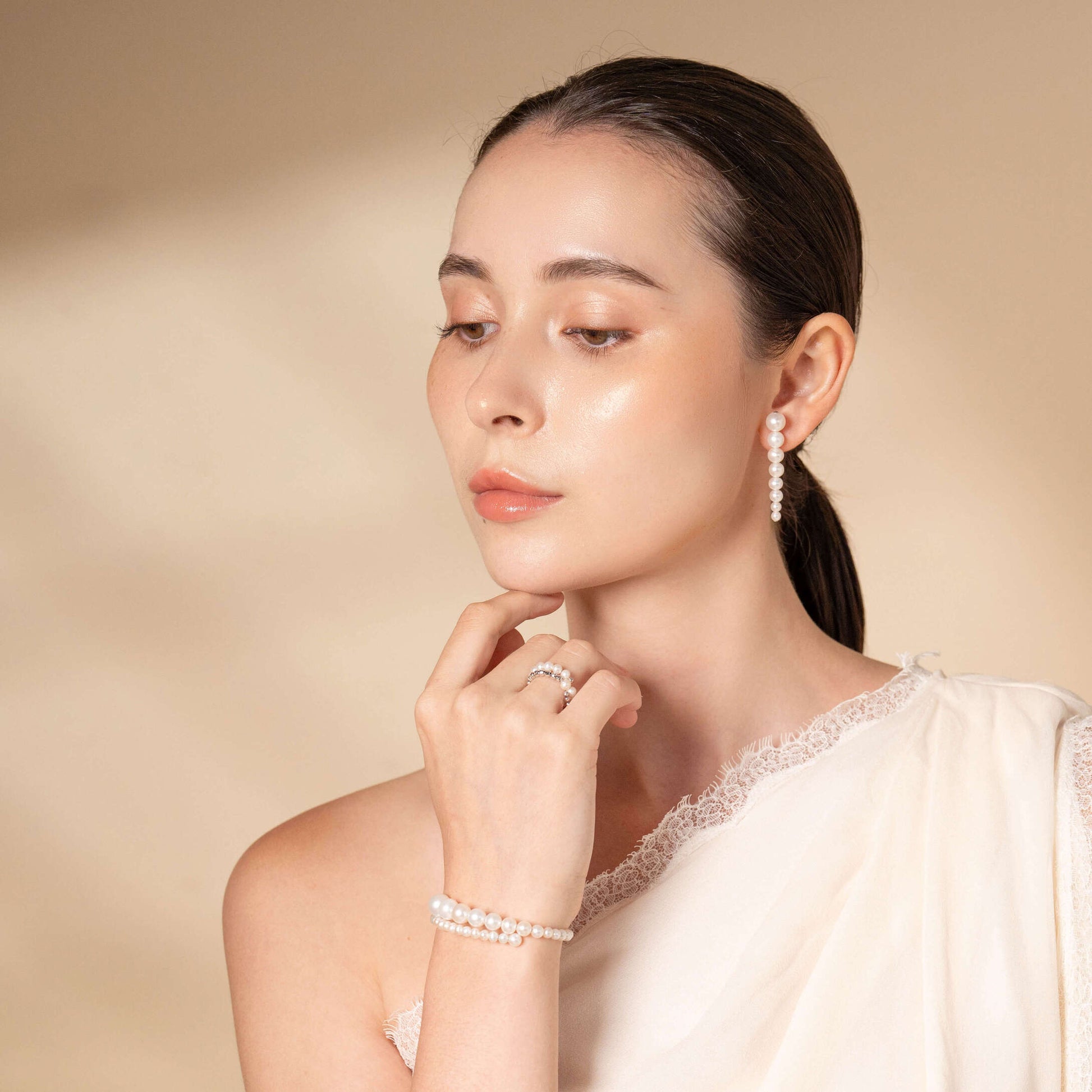 Elevate your fashion game with Stella Piercing: a woman radiating grace in a white dress and exquisite earrings.