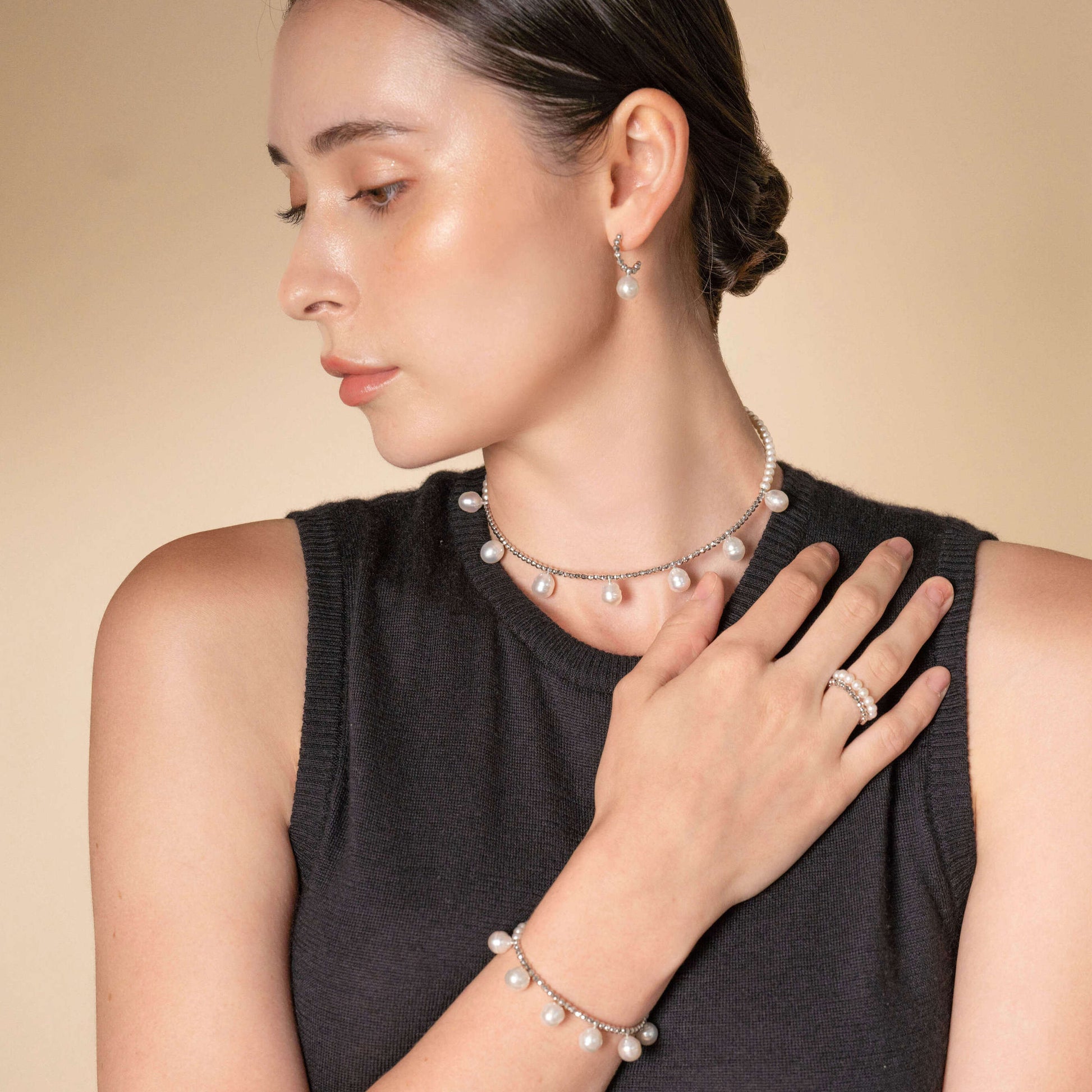 Elevate your style with a woman exuding grace, wearing a Pearl Dot x White Gold Pierce and necklace.