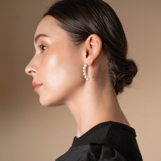 Enhance your style with elegance - a woman in a chic black top and stunning earrings.