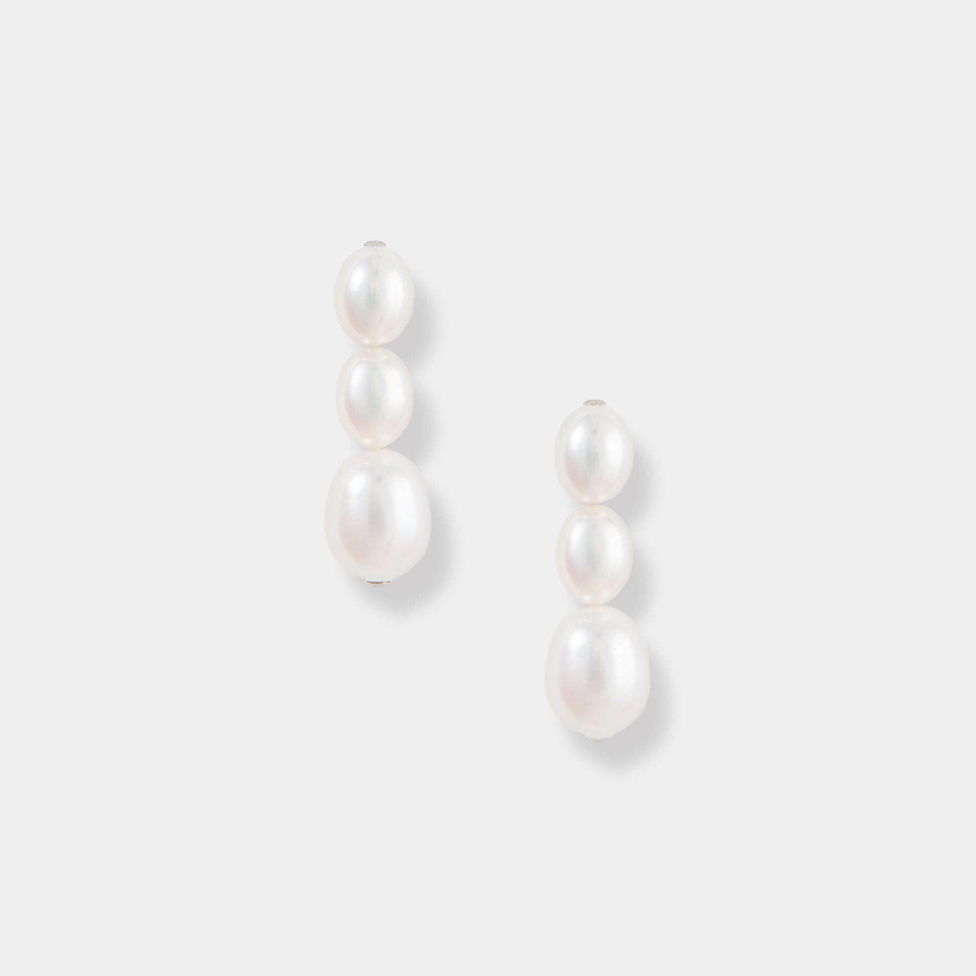 Elevate your style with these stunning oval pearl drop earrings against a clean white backdrop. A timeless accessory.