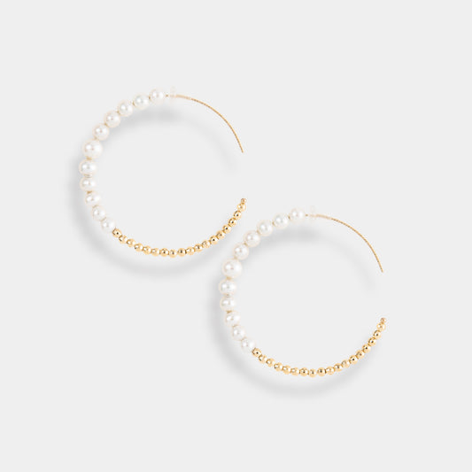 Elegant gold hoop earrings with lustrous pearls, perfect for adding a touch of sophistication to any outfit.