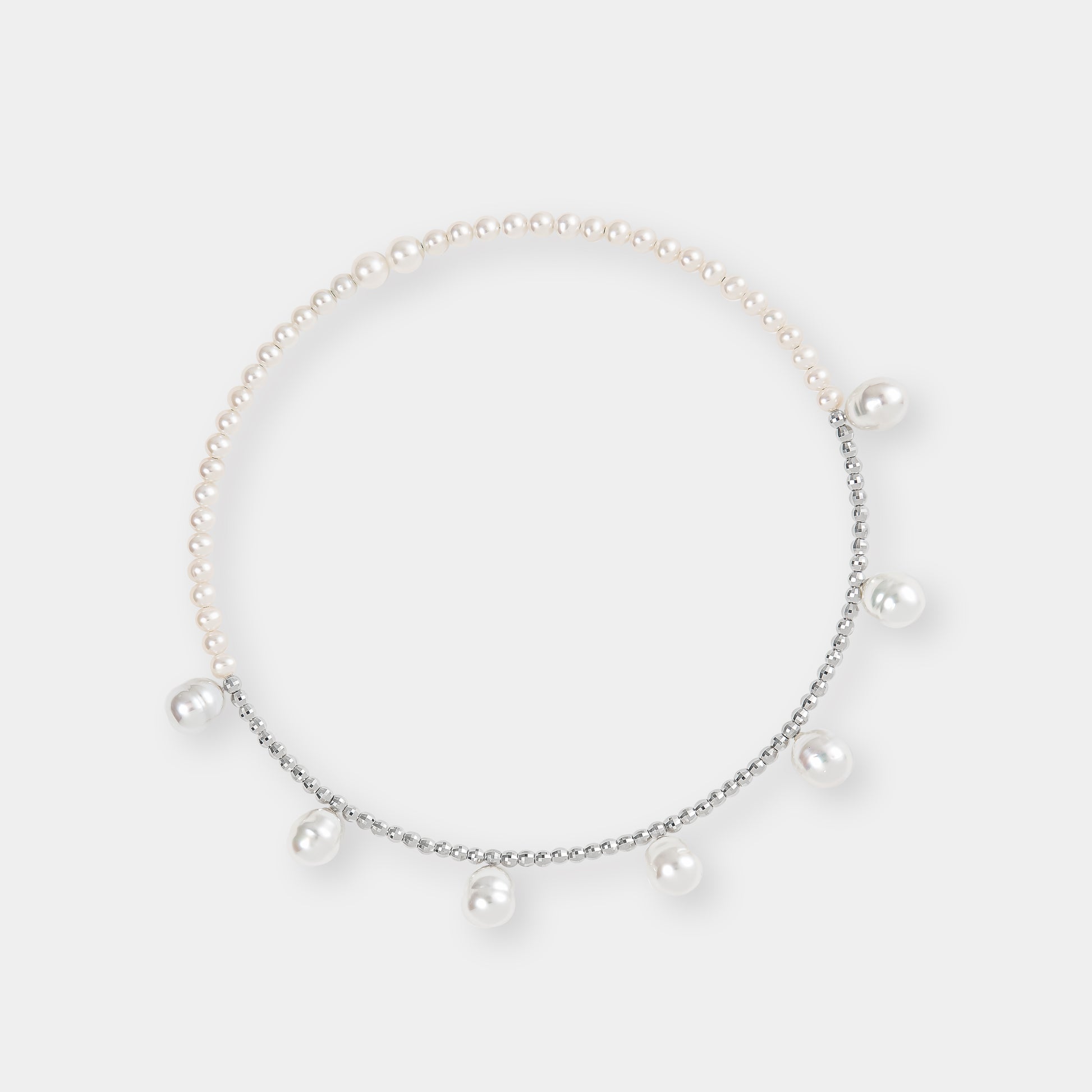 Luxurious pearl and white gold beads against a clean white backdrop, a stunning accessory for any occasion.