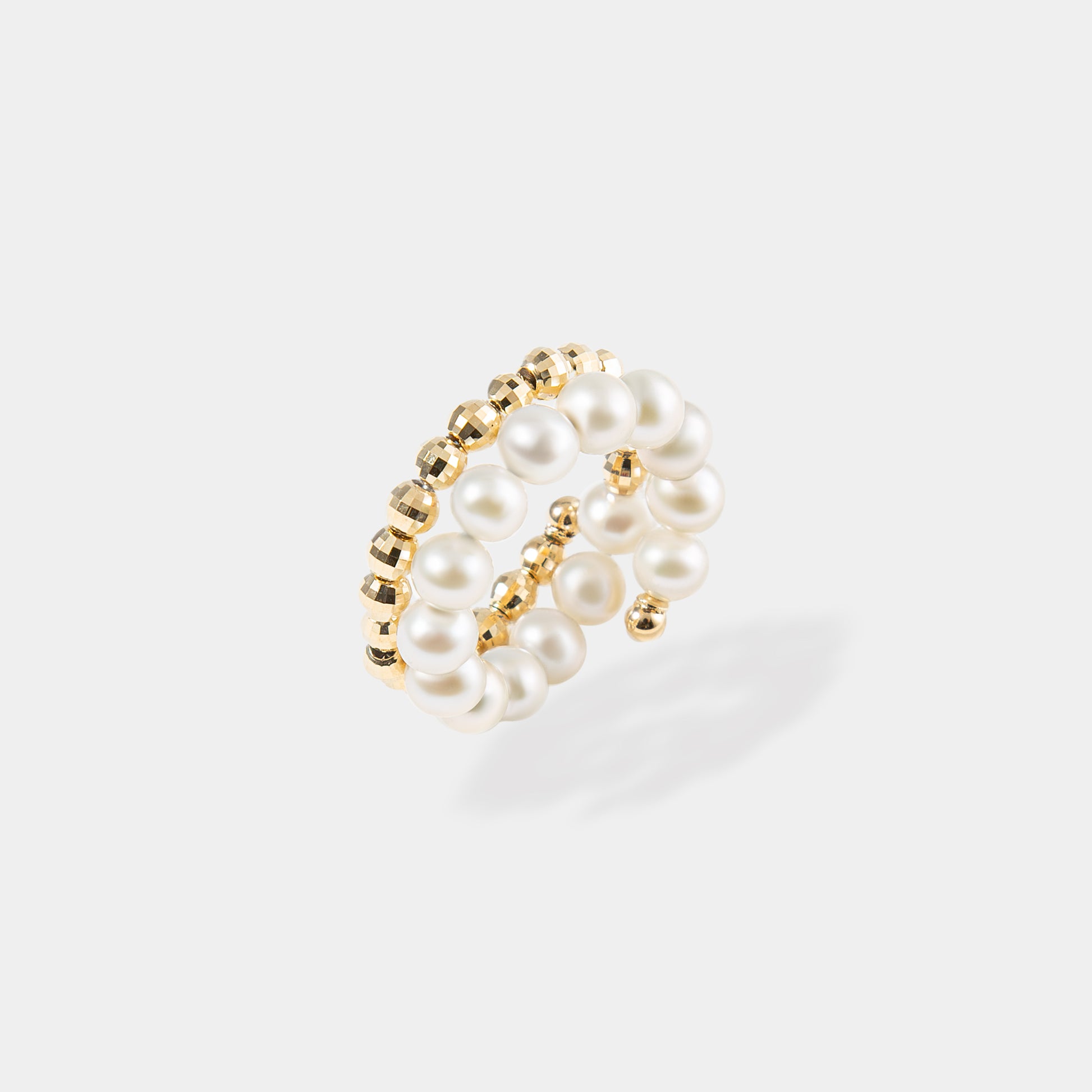 Elegant gold and white pearl ring with a spiral design, perfect for adding a touch of sophistication to any outfit.
