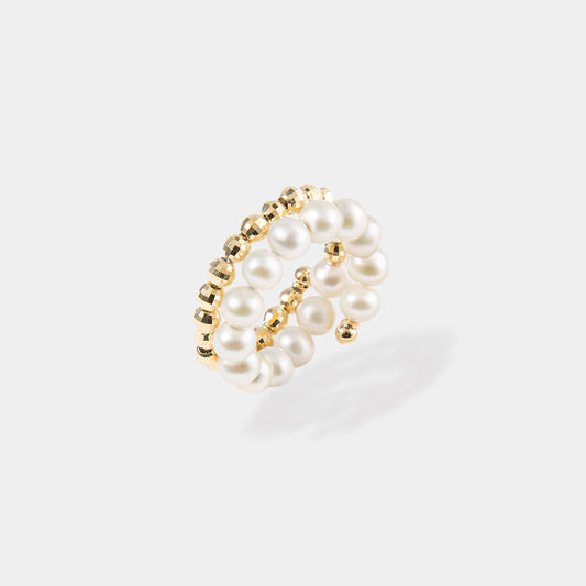 Elegant gold and white pearl ring with a spiral design, perfect for adding a touch of sophistication to any outfit.