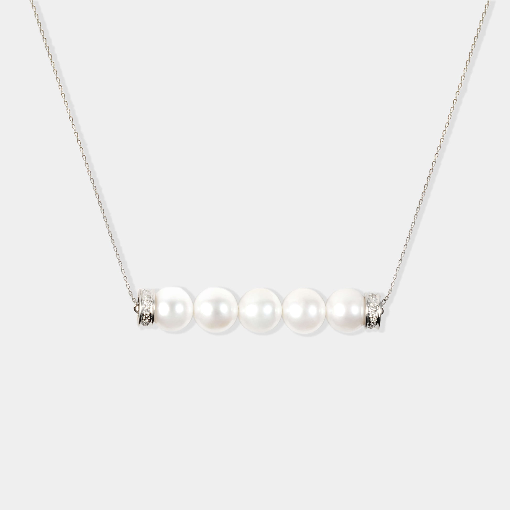 Elegant white pearl necklace with four pearls on a silver chain. Perfect for adding a touch of sophistication to any outfit.