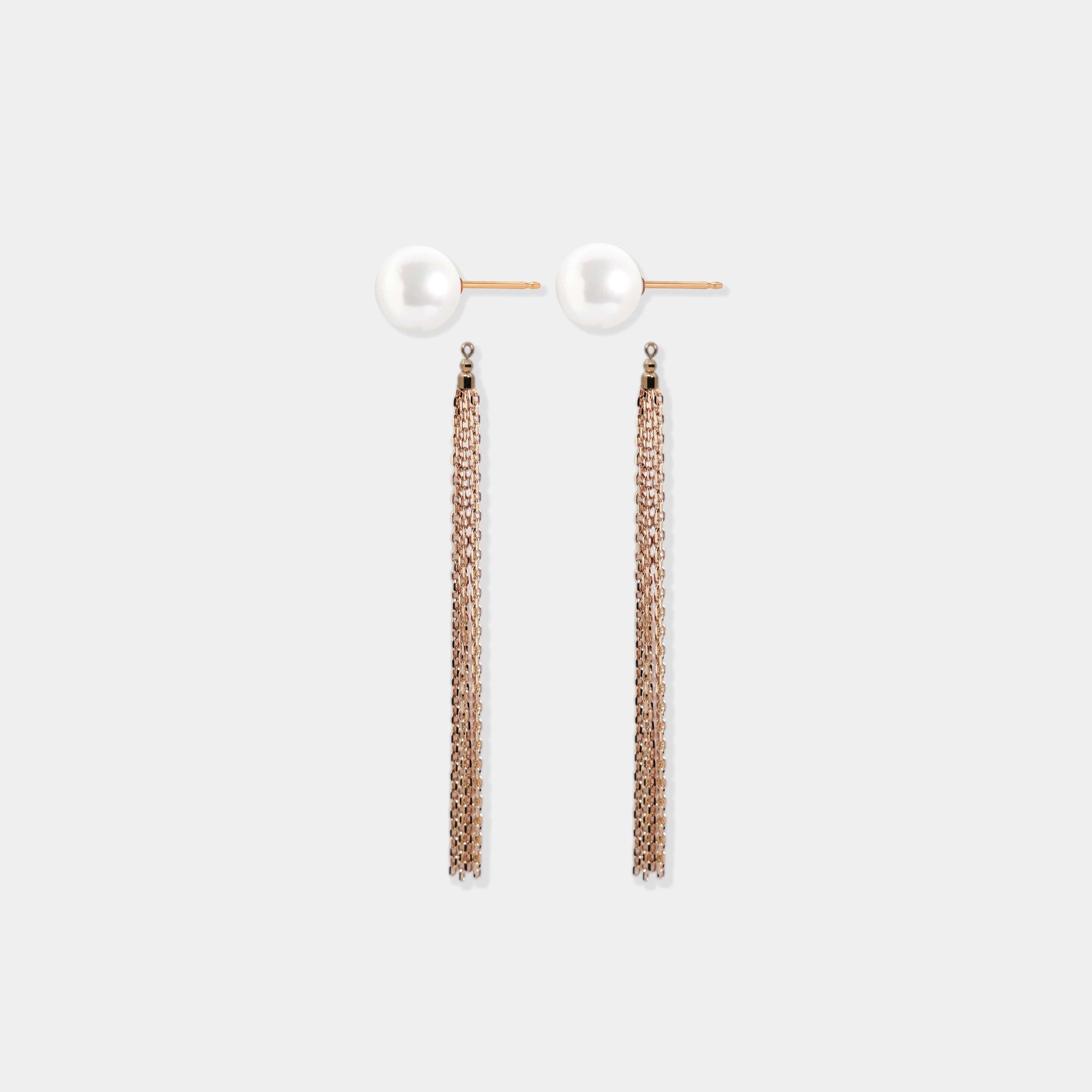Stylish pearl and gold earrings on white surface, Pearl + Fringe Piercing
