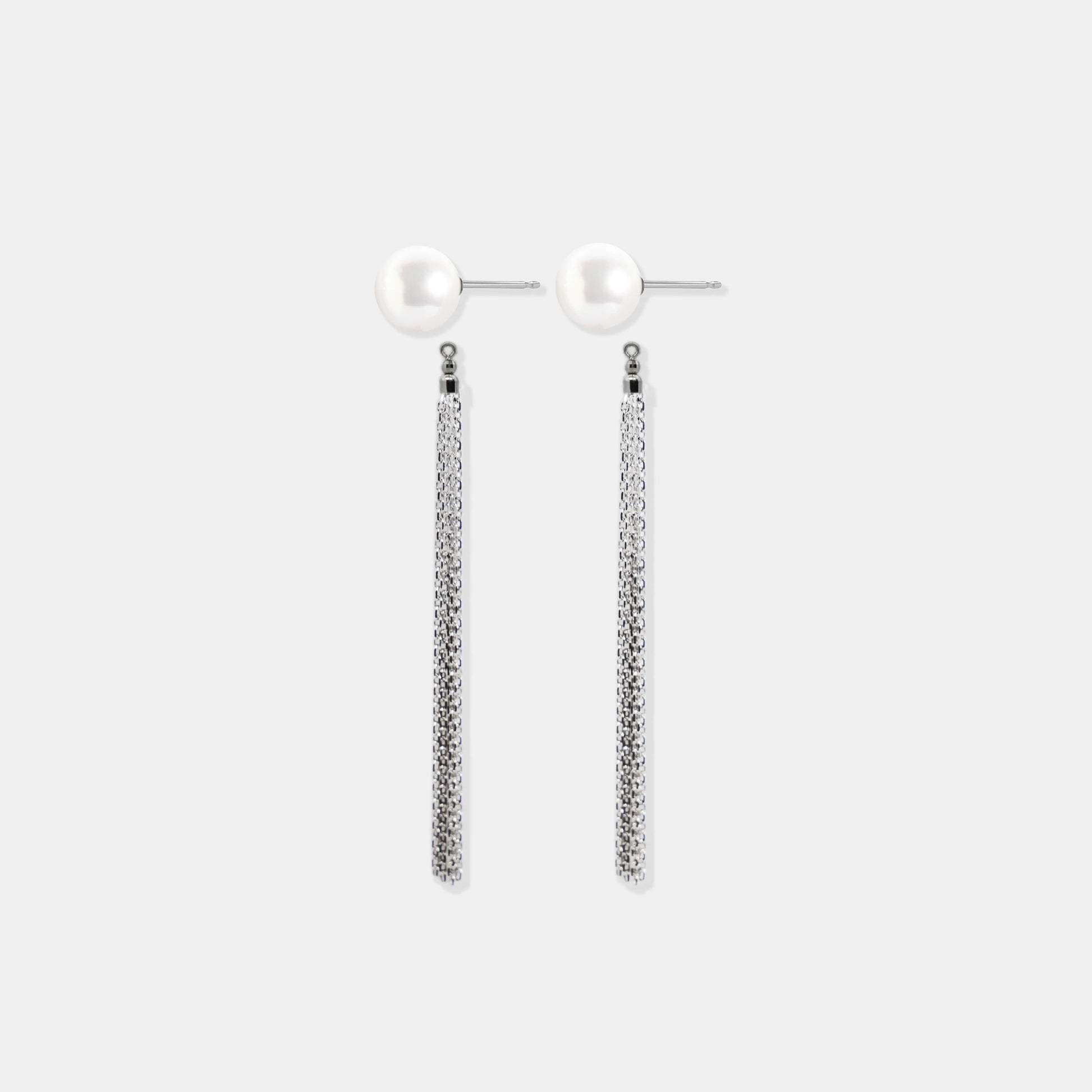 Stylish platinum earrings adorned with pearl and chain, showcasing Pearl + Fringe Piercing.
