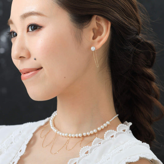 Enhance your style with this elegant woman wearing a gold necklace and pearl earrings. Perfect for any occasion!