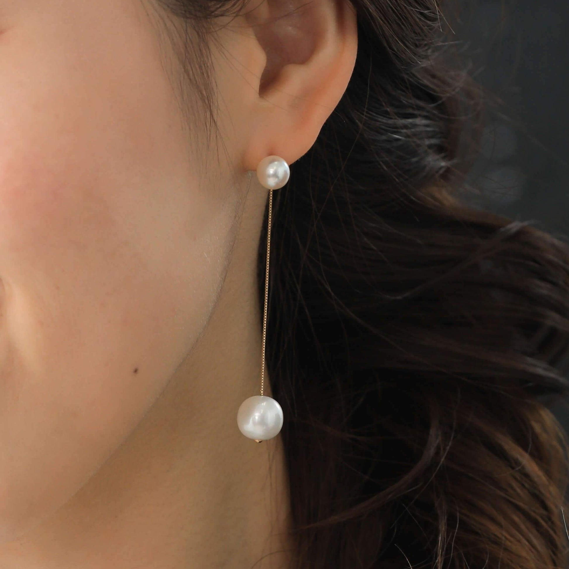 Enhance your elegance with Sway Pearl Piercing - a radiant woman wearing pearl earrings and beaming with joy.