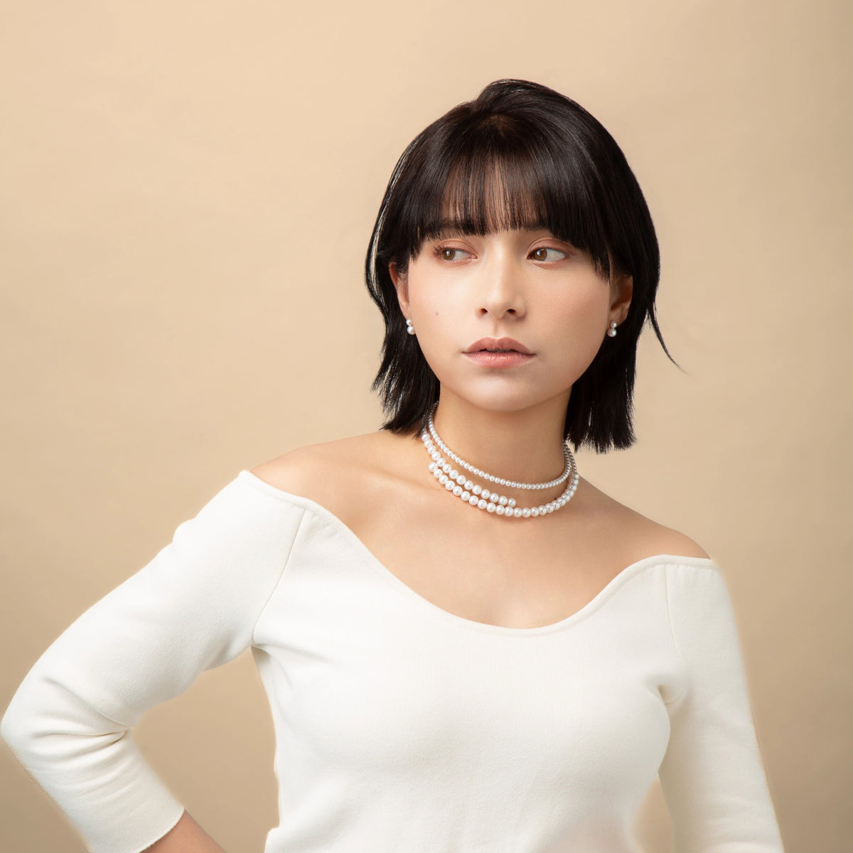 Infinity Necklace worn with a white top, three-quarter view