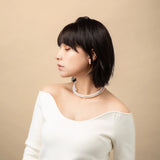 Infinity Necklace worn with a white top, profile view
