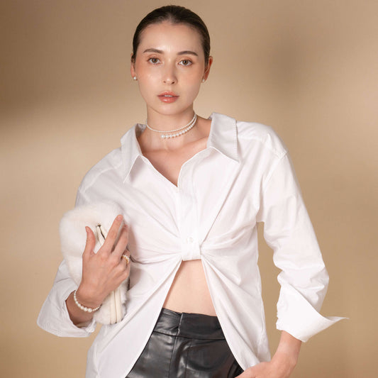 Embrace sophistication with a fashionable woman wearing a white shirt and leather pants, accentuated by an exquisite Spiral Pearl Choker.