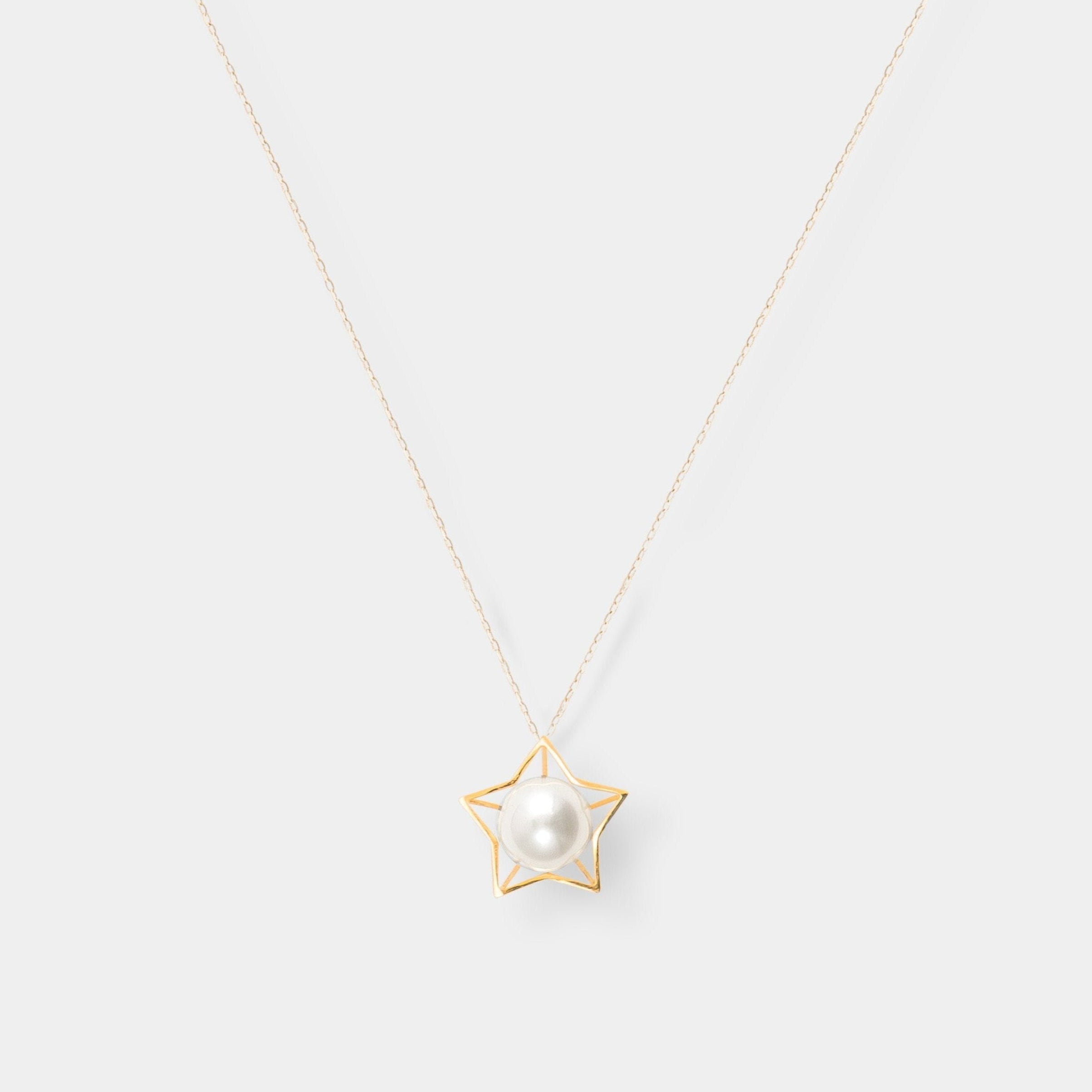 Enhance your elegance with a stunning gold star necklace adorned with a lustrous pearl. Elevate your style effortlessly.