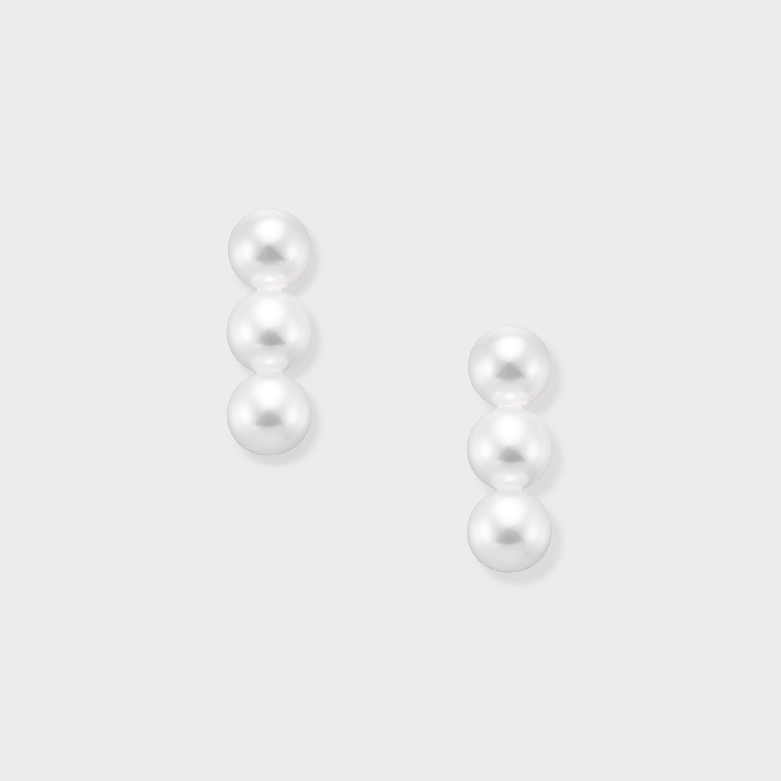 Elevate your look with our Triple Pearl Pierce. Featuring a modern vertical design with three graduated freshwater pearls, these studs offer a chic, architectural twist on a classic favorite. Made in 18K Yellow Gold.