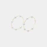 Embrace sophistication with these captivating gold hoop earrings embellished with delicate white pearls. A must-have for any jewelry collection.