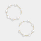Enhance your look with these stunning gold hoop earrings featuring lustrous white pearls. A timeless accessory for every fashionista.
