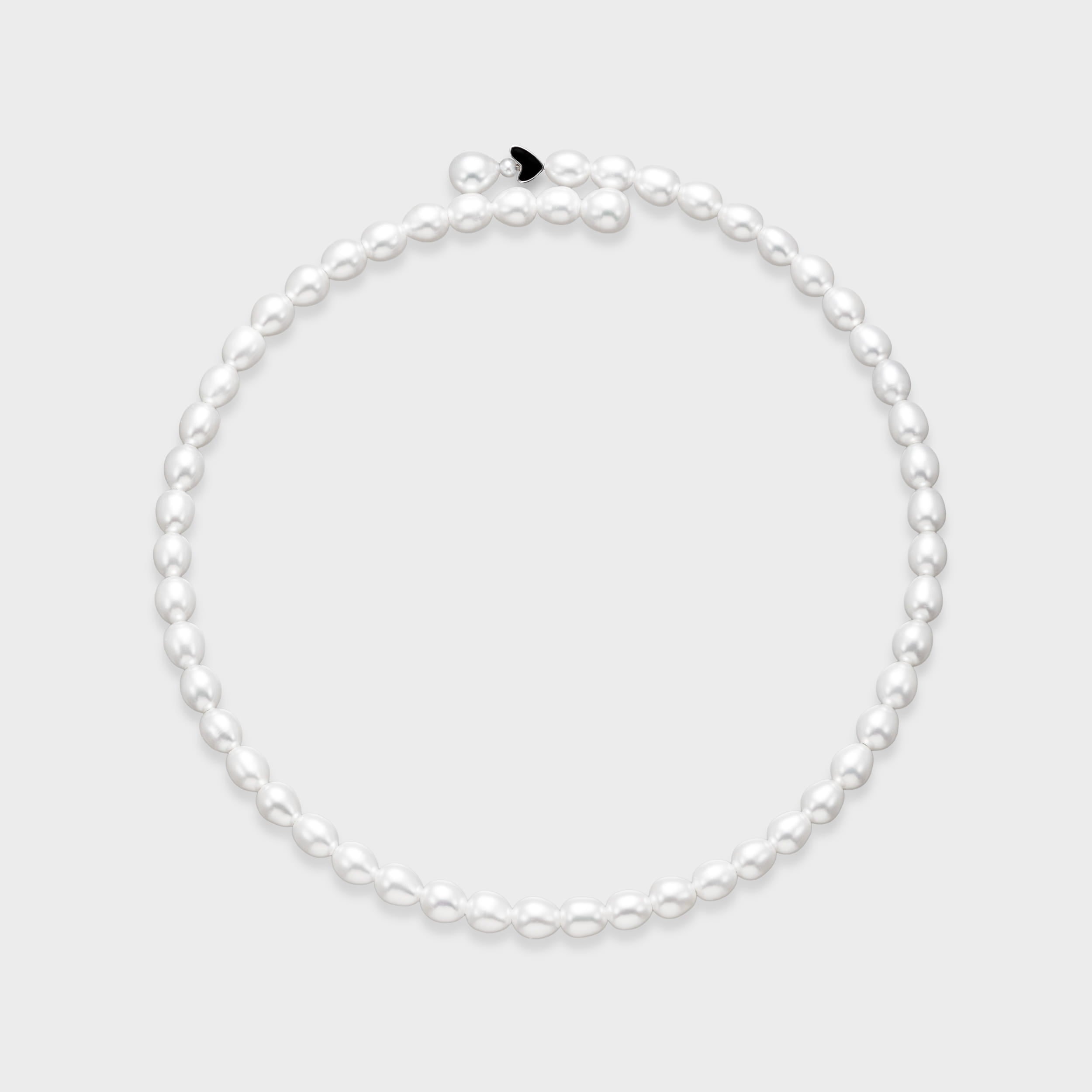White oval freshwater pearl necklace with small black enamel heart charm accent on a light gray background.