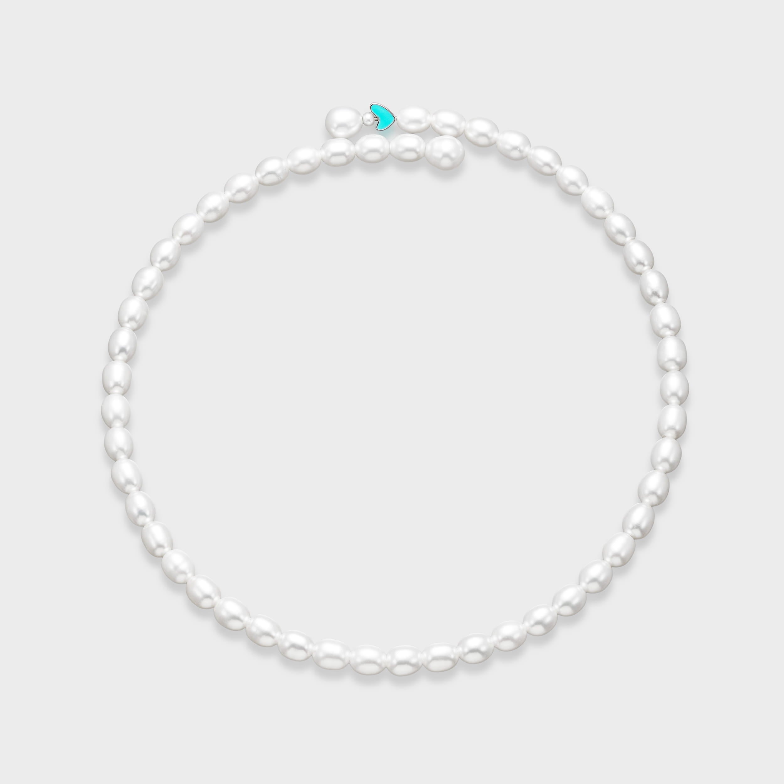 White oval pearl necklace with small turquoise enamel heart charm centered at the front on a light gray background