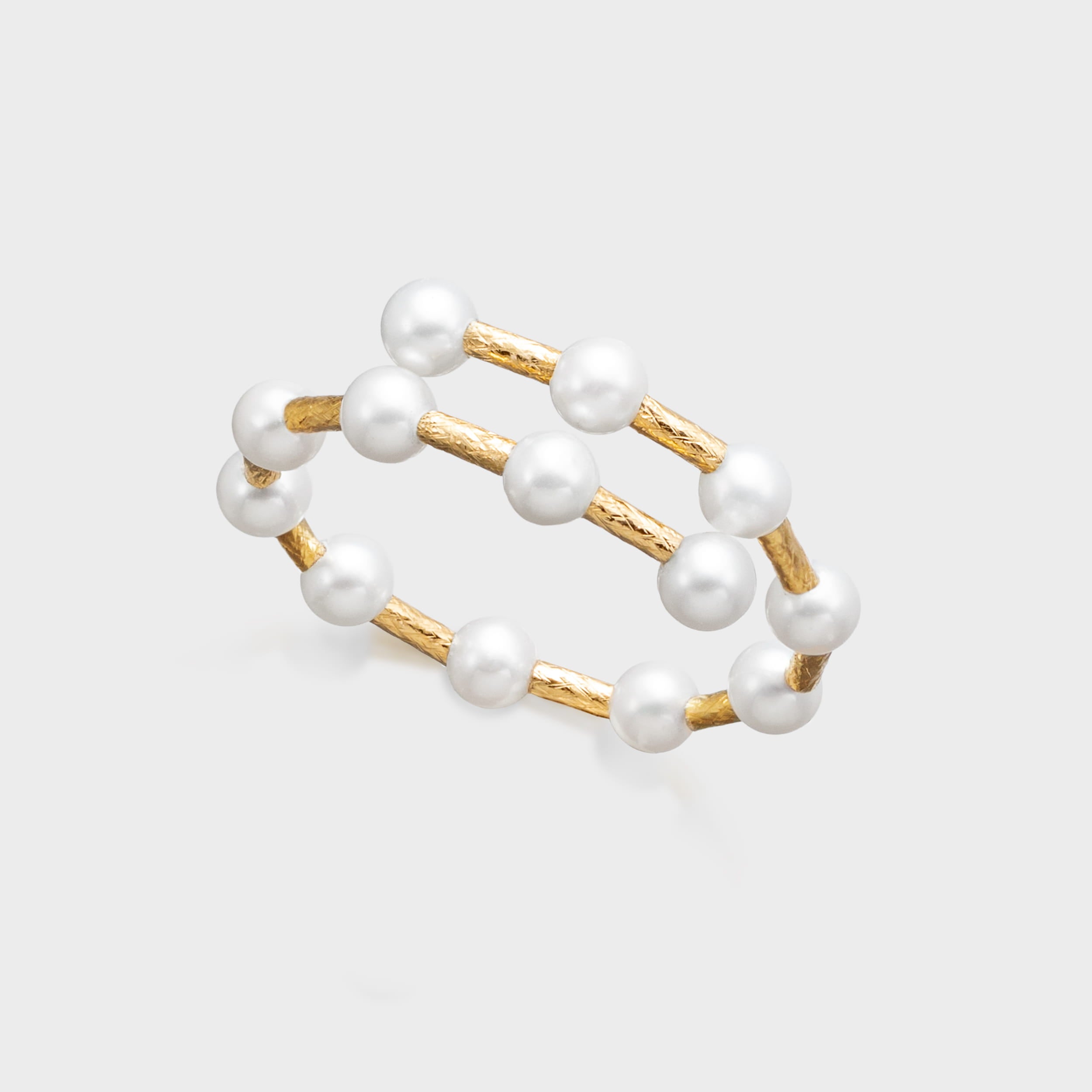 Double-layer gold and pearl bracelet featuring round white pearls and textured gold bar links.