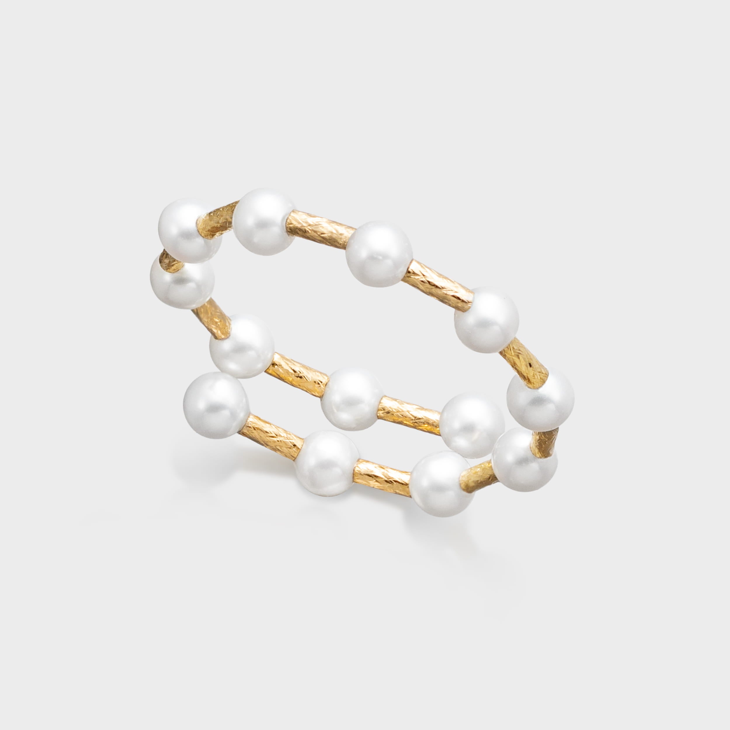 Double-layer gold and pearl bracelet featuring round white pearls and textured gold bar links.